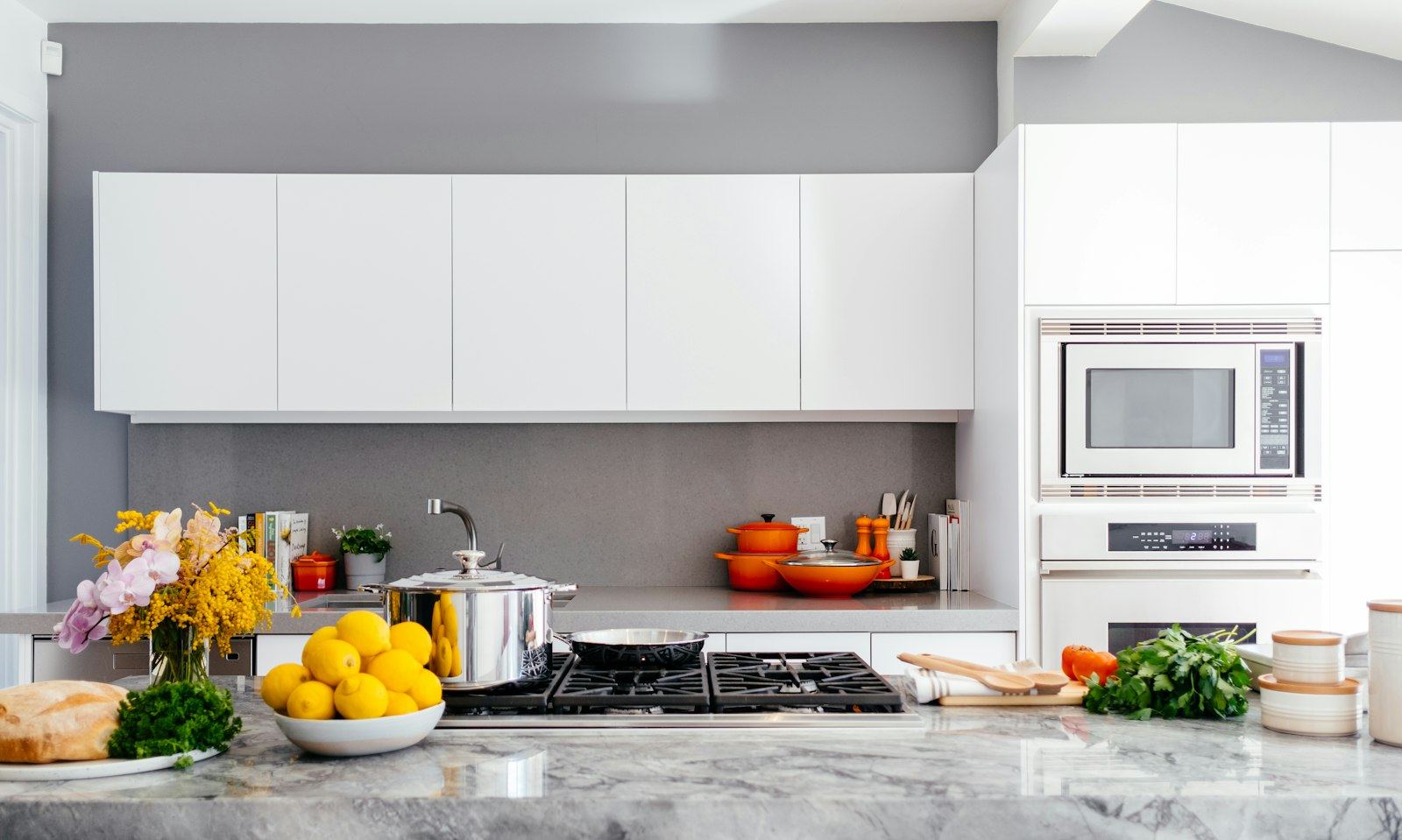 Bright, freshly cleaned white kitchen with fruit on the counter